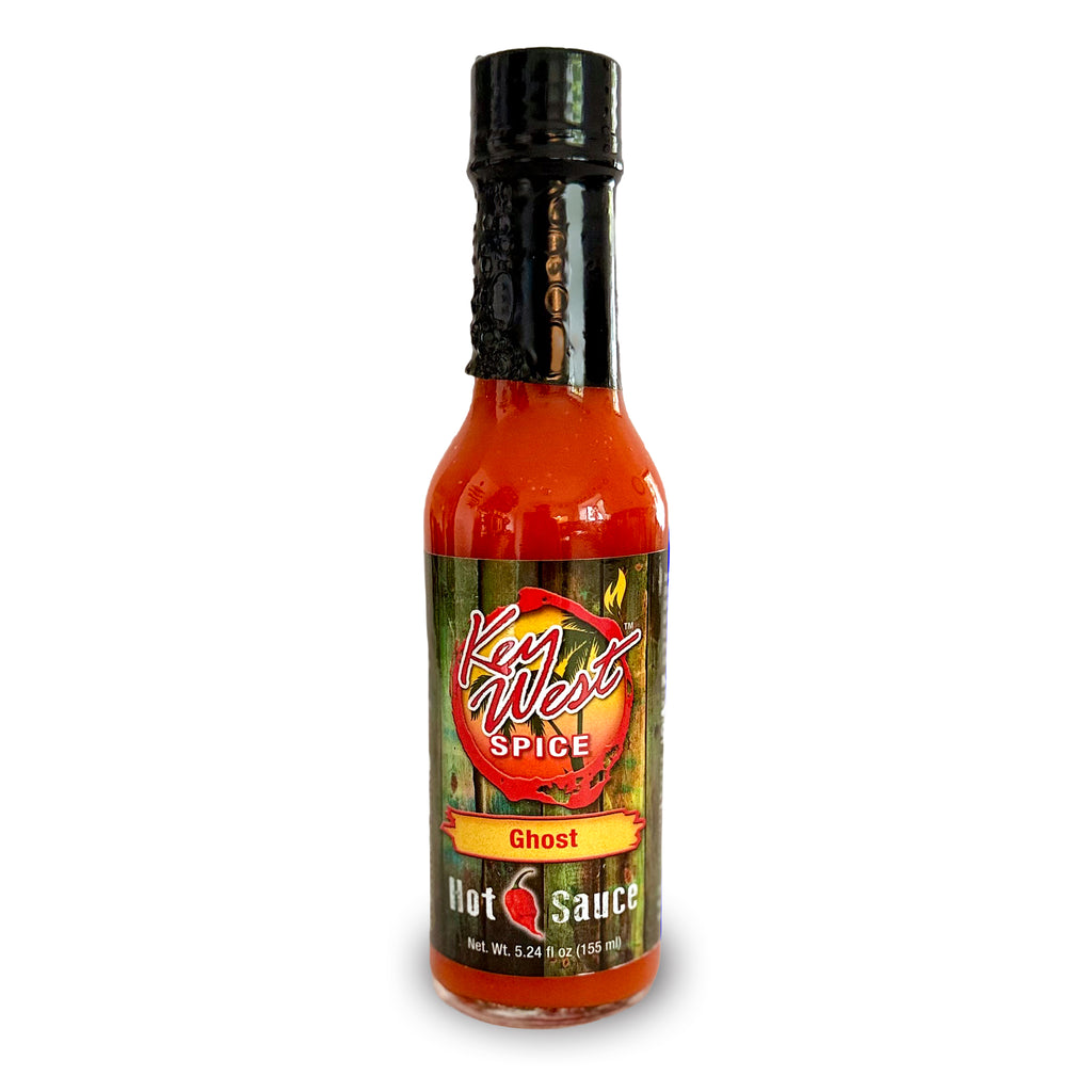 A bottle of Key West Spice Ghost Hot Sauce on a plain white background. The bottle is filled with bright red-orange sauce and features a black cap and a label with green, red, and orange colors.