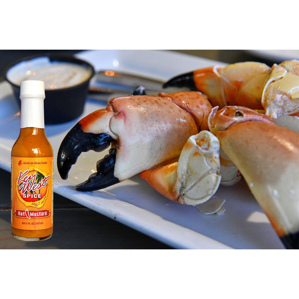 Key West Spice hot mustard in a 5 oz jar, with stone crabs and mustard spread on a plate, ready to serve.