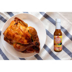 Key West Spice Mango Fusion Hot Sauce bottle next to grilled chicken, showcasing vibrant mango flavor and spicy sauce.