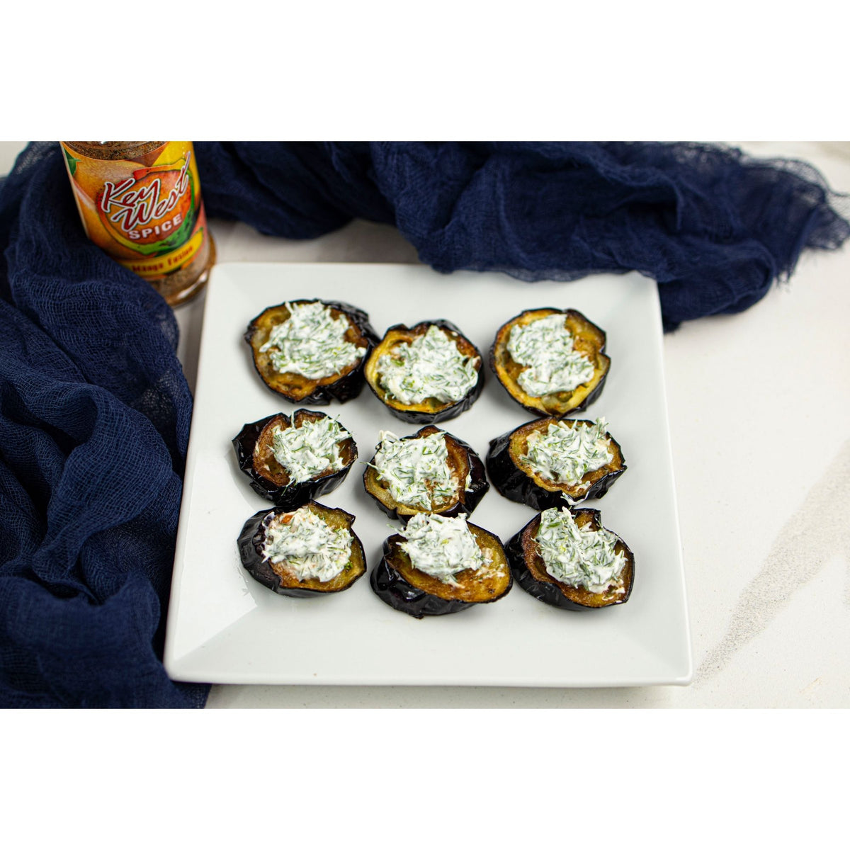 Key West Spice Mango Fusion salt-free and sugar-free seasoning blend with eggplant and mango pieces in a bowl.