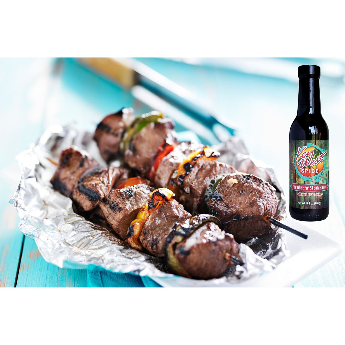 Key West Spice Paradise Steak Sauce with Vidalia® Onions served with grilled kabobs in a close-up image.