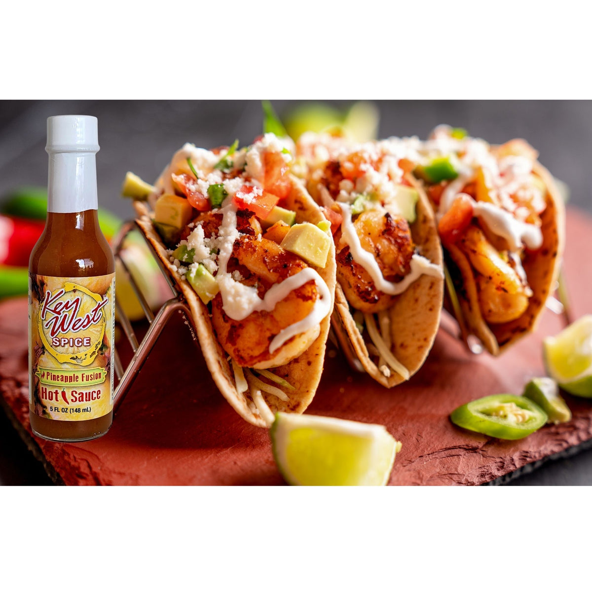 Key West Spice Fusion Hot Sauce assortment with pineapple flavor, shown alongside tacos topped with hot sauce